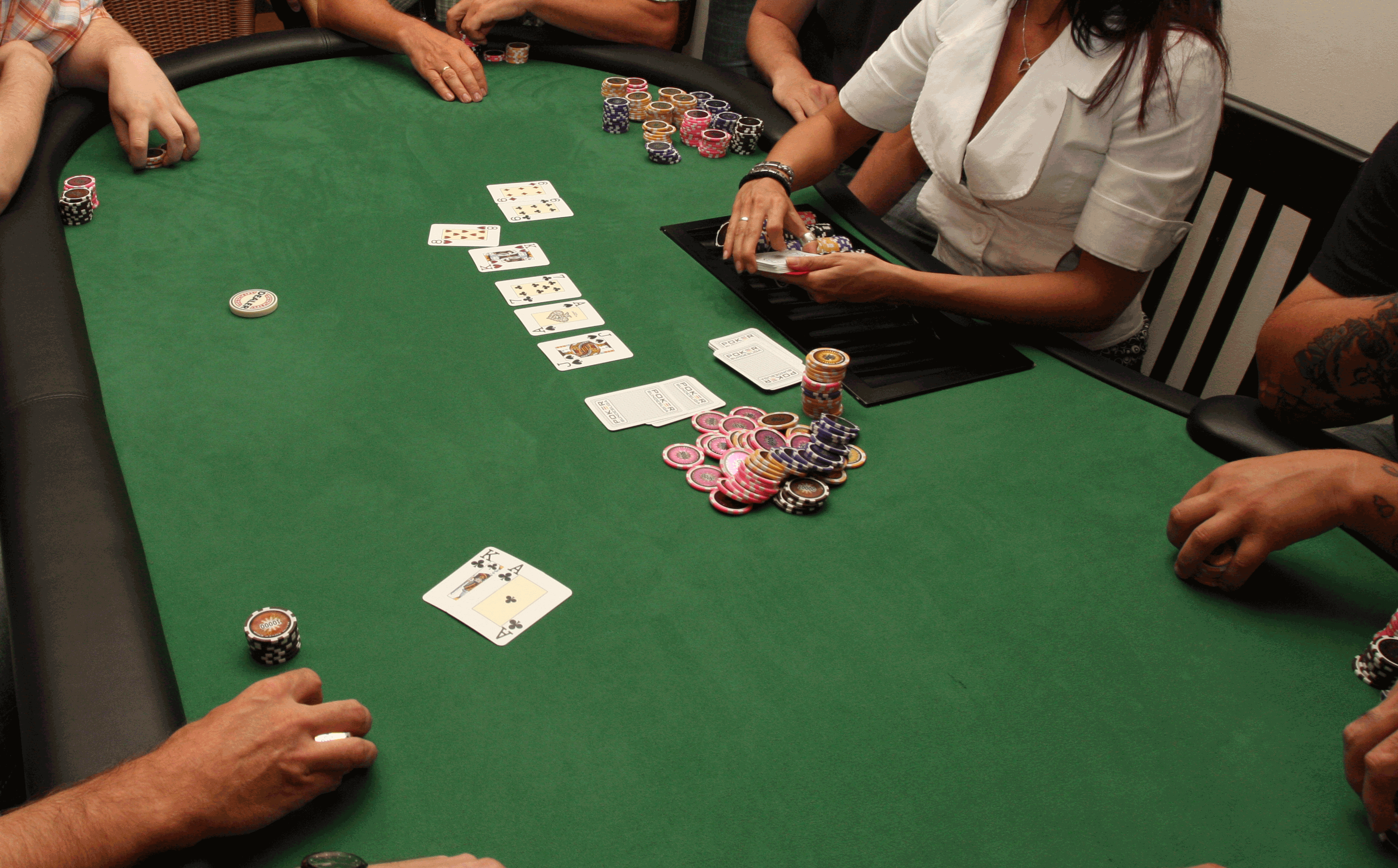 A close-up view of a poker table with cards and chips